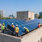 Technicians installing solar panels on a high-rise rooftop in Navi Mumbai with city skyline background.