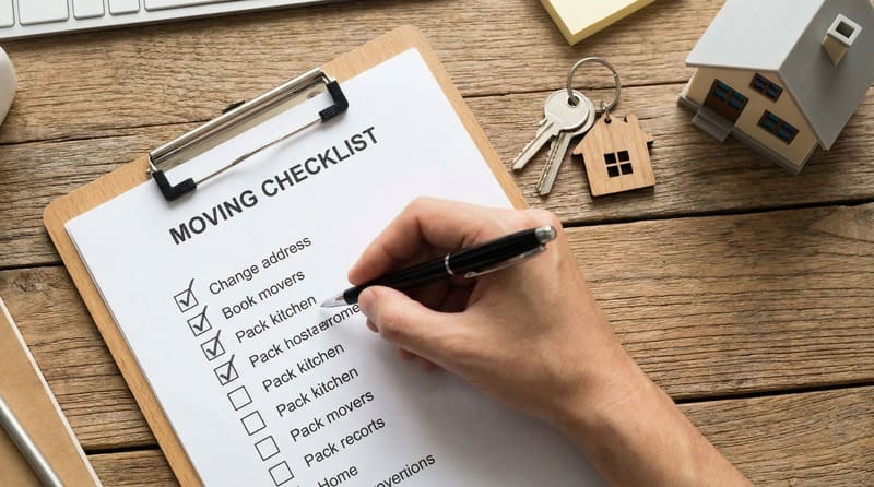 Person checking moving checklist on clipboard.