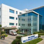 Modern multi-specialty hospital building exterior in Navi Mumbai with emergency entrance and landscaped surroundings