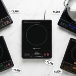 Top view of five induction cooktops from Indian brands with LED displays and steel cookware on white marble surface