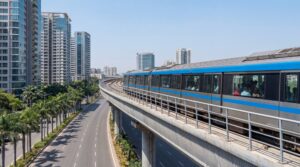 Navi Mumbai Metro train on elevated viaduct passing through modern city with palm trees and residential towers