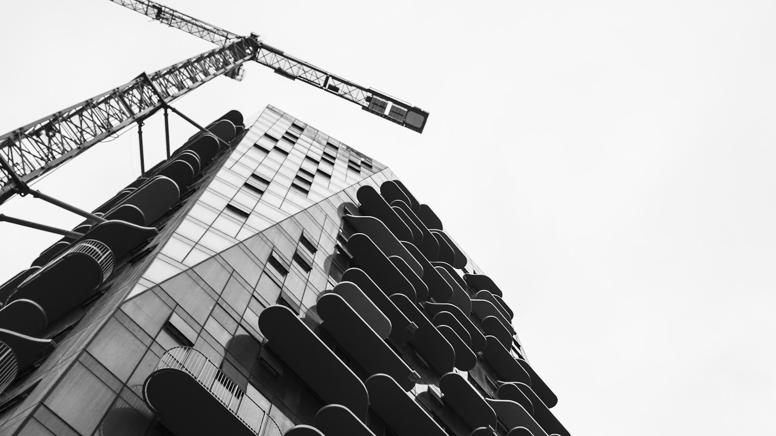 Old residential building beside a new high-rise under construction with crane, illustrating society redevelopment in Navi Mumbai