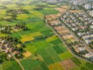 Illustrative landscape of farmland and housing with decorative parcel lines.
