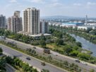 Illustrative AI-generated view of apartment towers near a creek and highway, not an actual Airoli location.