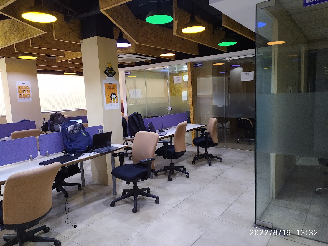 Empty open-plan coworking desks and chairs in a generic shared workspace, used here as an illustrative image and not a photo of any specific Navi Mumbai centre