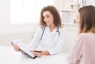 Dermatologist reviewing notes with a patient during a consultation