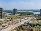 Illustrative AI-generated view of under-construction towers near a creek and mangroves, not an actual Dronagiri location.
