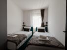 Two neatly made single beds in a shared bedroom, illustrative image not depicting a specific Navi Mumbai property