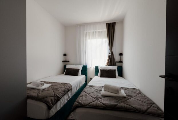 Two neatly made single beds in a shared bedroom, illustrative image not depicting a specific Navi Mumbai property