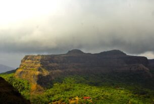 Panoramic view of Visapur Fort's flat plateau under monsoon clouds, seen from neighbouring Lohagad Fort