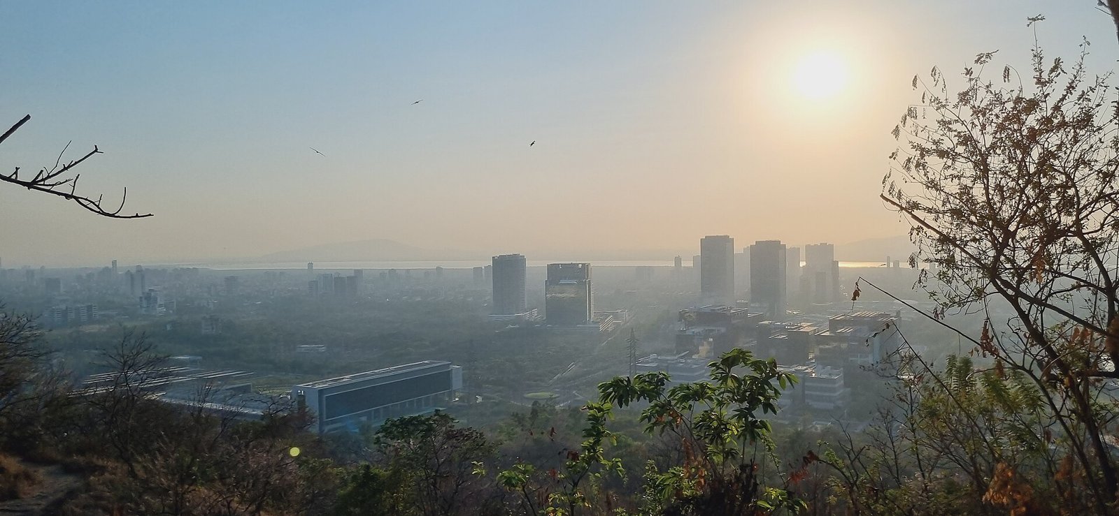 Hazy view of the Navi Mumbai skyline at sunset from a hill