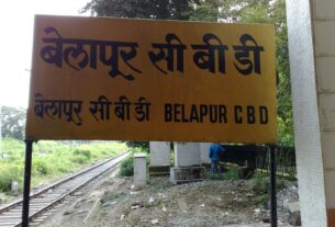 Belapur CBD station name board in Hindi and English beside the railway track