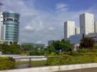 Glass and concrete office towers beside landscaped gardens under a blue sky in Navi Mumbai
