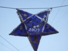 A blue star shaped Christmas lantern hanging from a wire against a pale sky in Mumbai