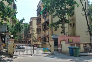 Gate and entrance of a CIDCO flat housing society in Sector 10, Sanpada, with residential buildings and trees behind