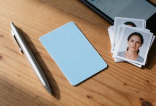A blank driving licence card, pen and passport-size photos arranged on a desk, AI-generated illustrative render
