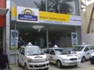 White learner cars with L boards parked outside a Maruti Suzuki driving school branch