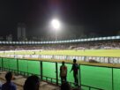 Floodlit football match with spectators in the stands at the Mumbai Football Arena at night