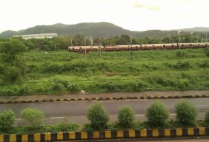 A local train running past green hills near Ghansoli