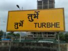 Yellow railway station board reading Turbhe in Hindi and English