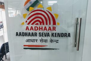 An Aadhaar Seva Kendra counter with applicants