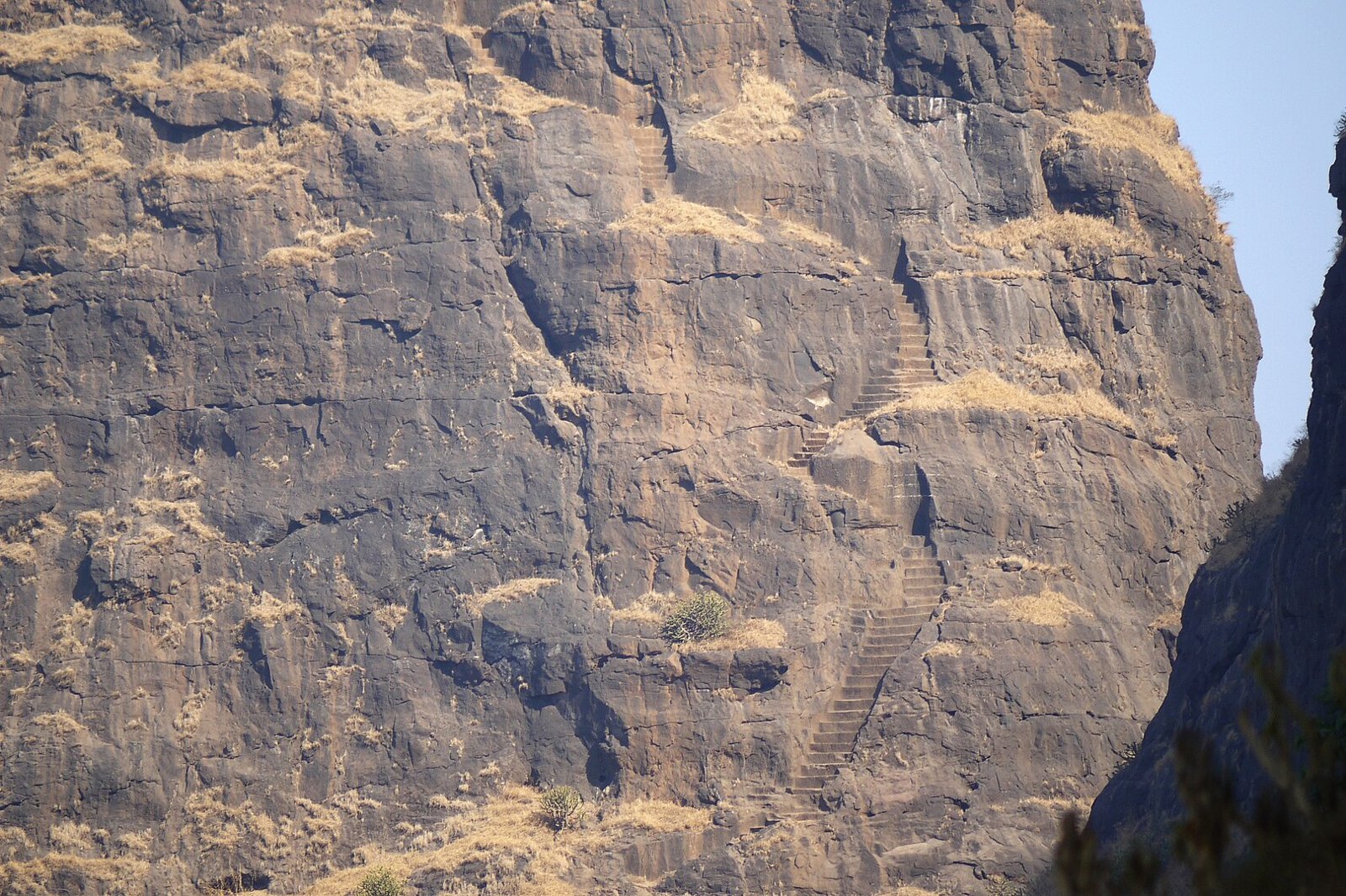 Rock-cut staircase climbing the steep cliff face of Kalavantin Durg
