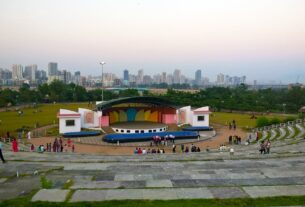 Open-air amphitheatre in Central Park, Kharghar, with the city skyline behind