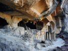 Weathered rock-cut Buddhist caves with carved facades in a cliff face near Karjat