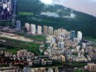 Aerial view of high-rise residential towers beside mangroves in Navi Mumbai