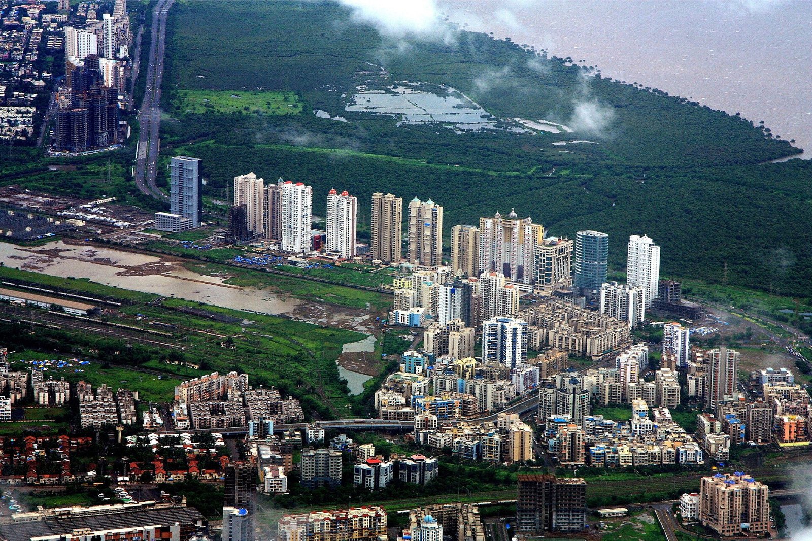 Aerial view of high-rise residential towers beside mangroves in Navi Mumbai