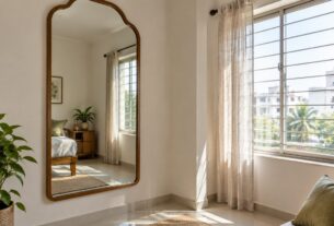 Mirror placed near a window reflecting natural light into a small Indian apartment room, AI-generated illustrative render