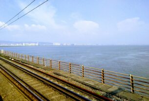 View of Thane Creek and a distant city skyline from the Vashi railway bridge