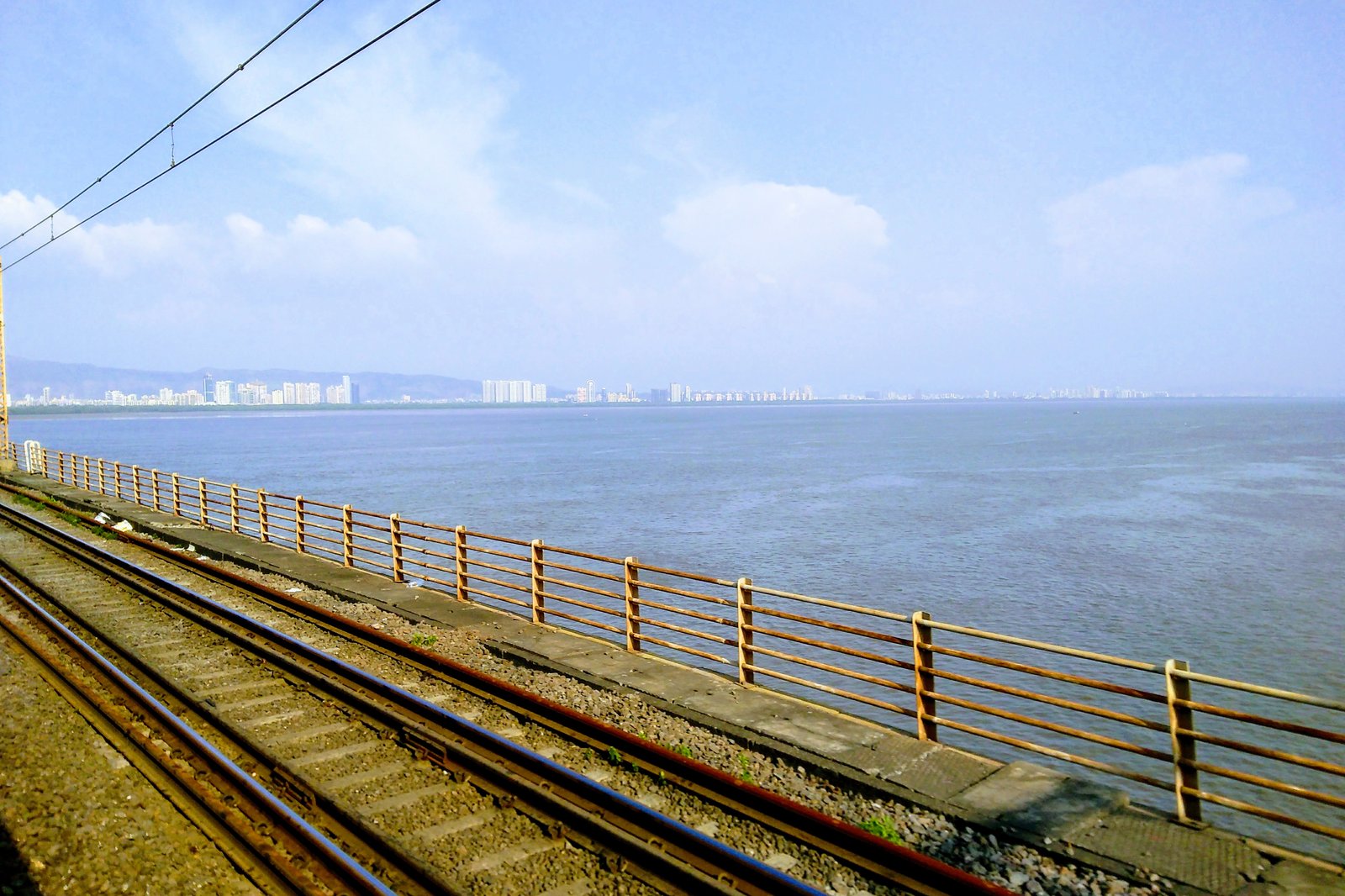 View of Thane Creek and a distant city skyline from the Vashi railway bridge