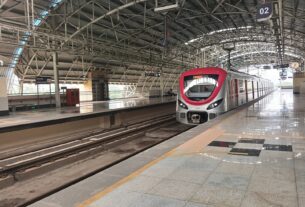 A silver and red Navi Mumbai Metro Line 1 train at the platform of Utsav Chowk station in Kharghar