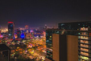 Navi Mumbai skyline at night, with lit towers and an open busy ground below