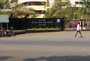 Black gate wall with Hindi lettering at the entrance of a cancer research and education centre in Kharghar, Navi Mumbai