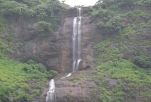 Pandavkada waterfall dropping down a green rock face in Kharghar