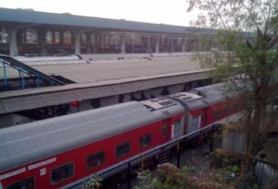 Red long-distance train at a platform of Panvel railway station seen from the footbridge