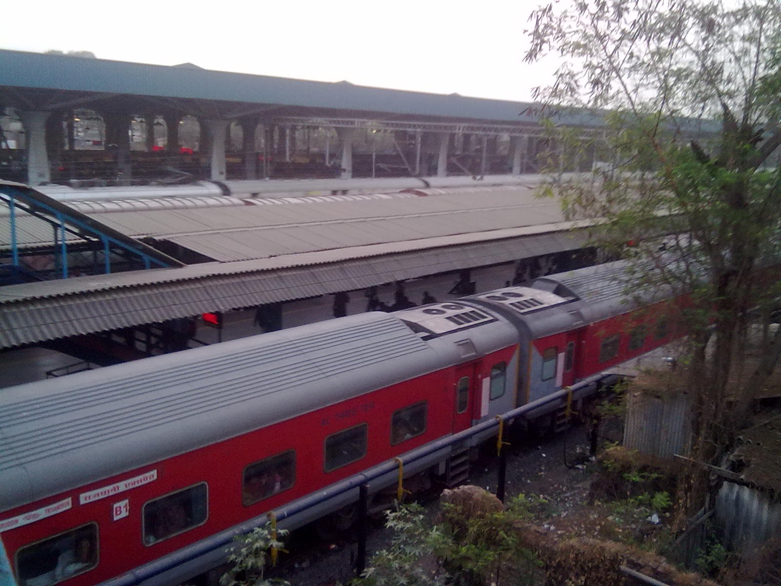 Red long-distance train at a platform of Panvel railway station seen from the footbridge