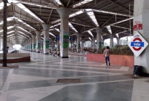 Inside Panvel railway station with a platform sign and the roof over the platforms