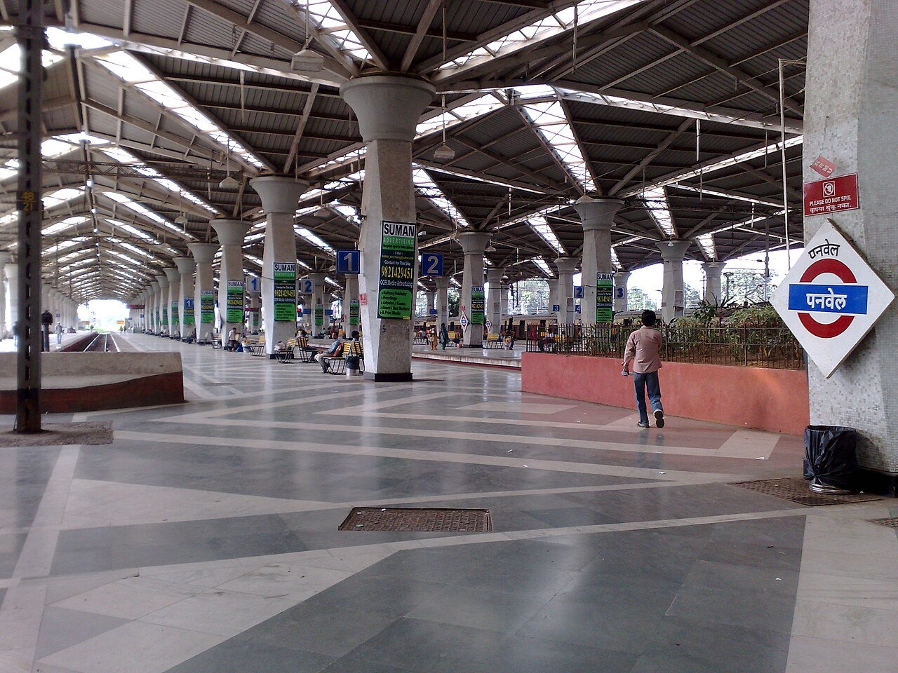 Inside Panvel railway station with a platform sign and the roof over the platforms