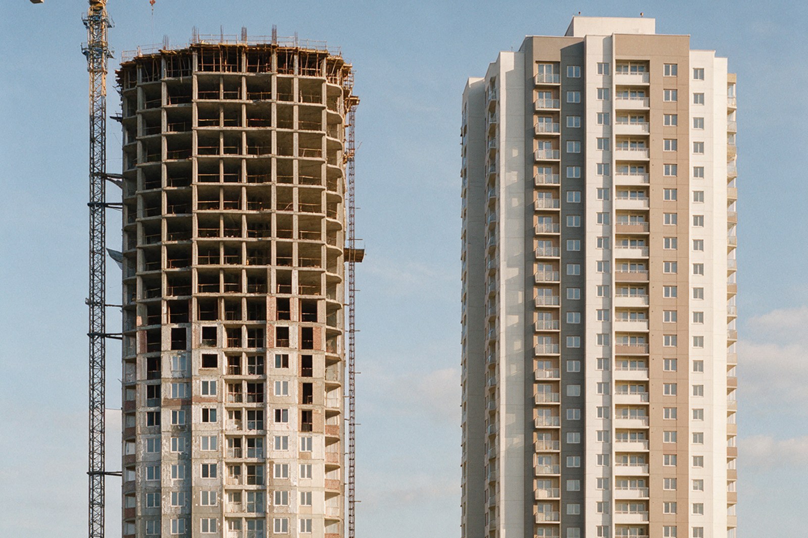 A half built tower beside a completed apartment tower
