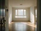 An empty living room with keys hanging on a hook by the door