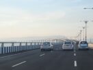 Cars on the Atal Setu sea bridge road with the bridge curving ahead over the water