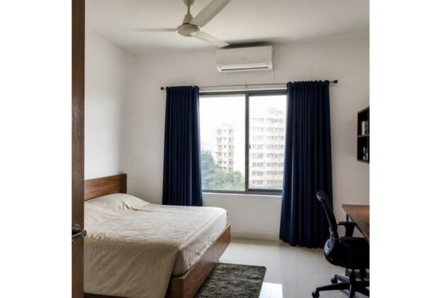 White walls with navy blue curtains in an Indian apartment living room, AI-generated illustrative render